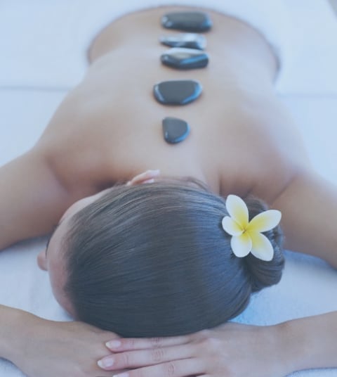 woman-relaxing-with-massage-stones-on-her-back-picture-id75593170