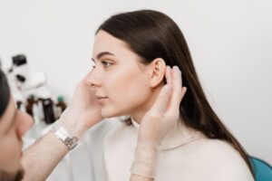 A doctor examining a patient’s ears to see if they’re a good candidate for otoplasty