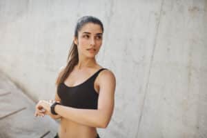 Woman prepares to go for a jog, enjoying her more active lifestyle after downsizing her breasts with cosmetic breast surgery.