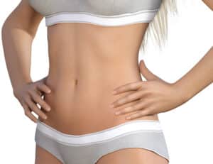 Woman shows a flat, toned tummy that looks natural even after abdominoplasty.