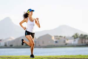 Suburban woman runs beside the water after completing her weight loss journey.