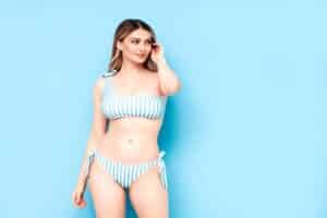 Woman looks stunning in her striped swimsuit after undergoing cosmetic procedures