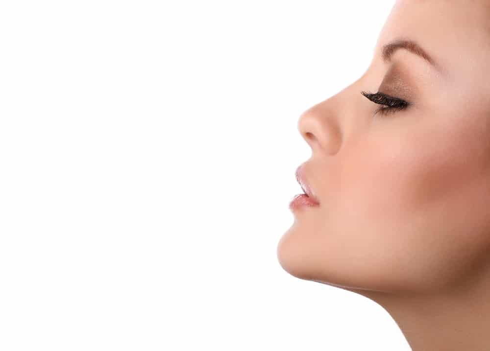 Woman tilts her face to showcase her chin.