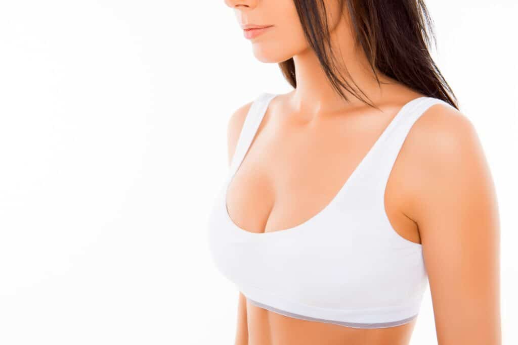Woman in white top has a nice physique after breast augmentation with lift.